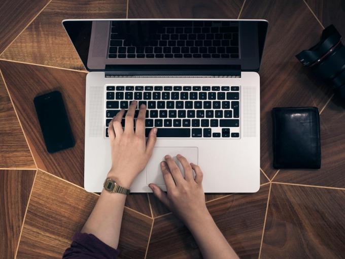 Hands typing on laptop